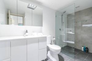 a white bathroom with a toilet and a shower at Reid5 2BR Apartment Close to Glebe Park and Canberra City in Canberra