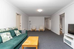 a living room with a green couch and a tv at Reid5 2BR Apartment Close to Glebe Park and Canberra City in Canberra
