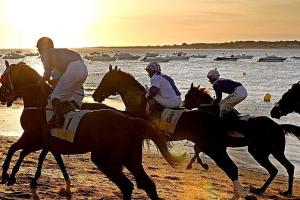 un grupo de personas montando a caballo en la playa en Relax en el corazón de Sanlúcar Netflix, en Sanlúcar de Barrameda