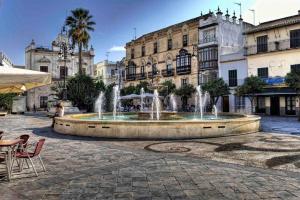 una fuente en medio de una plaza con edificios en Relax en el corazón de Sanlúcar Netflix, en Sanlúcar de Barrameda