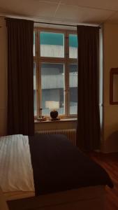 1 dormitorio con cama y ventana grande en Best Guest Vandrarhem, en Norrköping