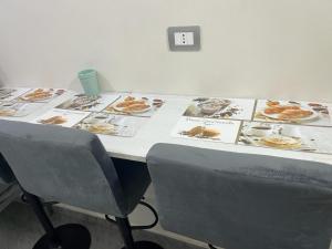 a table with pictures of food on it with a chair at B&b house napoli capodichino in Naples