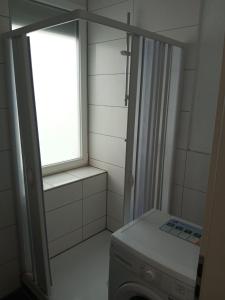 a bathroom with a window and a washing machine at Betty Zimmer in Heilbronn Zentrum in Heilbronn