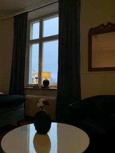 a living room with a table and a window at Best Guest Hotell och Vandrarhem in Norrköping +2 photos