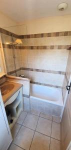 ein Badezimmer mit Badewanne und Waschbecken in der Unterkunft Les maisons Le Rouret - maeva Home - Maison 2 Pièces 5 Personnes - Confort MAE-3304 in Grospierres