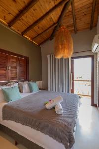 um quarto com uma cama grande e uma janela grande em Villa Meraki em Pipa