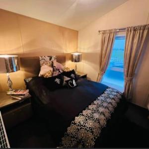 1 dormitorio con cama y ventana en Thorne Lodge - Seaview - 3 Bedroom en Whitstable