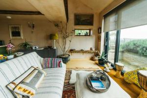 a living room with a white couch and a large window at Romantic Country Annex With Views - 10 min to Bath in Cold Ashton