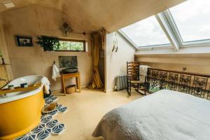 um quarto com uma banheira, uma cama e uma janela em Romantic Country Annex With Views - 10 min to Bath em Cold Ashton