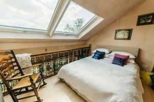 um quarto com uma cama grande e uma clarabóia em Romantic Country Annex With Views - 10 min to Bath em Cold Ashton