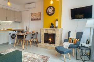 a living room with a fireplace and a table and chairs at Kostis Orange Resort in Volos