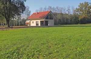 una casa blanca con techo rojo en un campo en Hiša Štolc, en Gornja Radgona