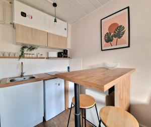 a kitchen with a wooden counter top and two bar stools at Maisonnette en Duplex - Cosy- Centre Ville in Verneuil d'Avre et d'Iton