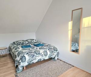 a bedroom with a bed and a mirror at Maisonnette en Duplex - Cosy- Centre Ville in Verneuil d'Avre et d'Iton