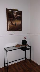 a glass table in a room with a picture on the wall at Best Guest Vandrarhem in Norrköping