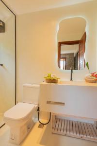 a bathroom with a toilet and a mirror at Villa Meraki in Pipa