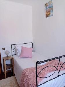 een slaapkamer met een bed met een roze kussen bij Casa da Calçada - Piso 2 in Seia