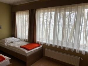 a bedroom with a bed and a window with trees at BF Hotel in Balatonföldvár