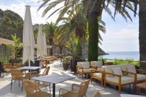un patio con tavoli, sedie e vista sull'oceano di Zel Costa Brava a Tossa de Mar