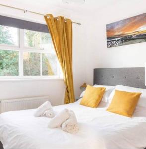 a bedroom with a white bed with towels on it at Beautiful Large Property, Sleeps 9 Walking Distance to the Sea , Beaches and Restaurants Fantastic Interior in Lyme Regis