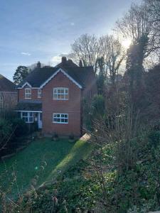 a red brick house in the middle of a yard at Beautiful Large Property, Sleeps 9 Walking Distance to the Sea , Beaches and Restaurants Fantastic Interior in Lyme Regis