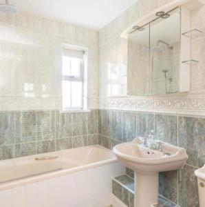 a bathroom with a sink and a bath tub and a sink at Beautiful Large Property, Sleeps 9 Walking Distance to the Sea , Beaches and Restaurants Fantastic Interior in Lyme Regis