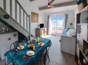 una habitación con una mesa con platos de comida. en Appartement face à la mer - Saintes-Maries-de-la-Mer en Saintes-Maries-de-la-Mer