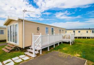 a mobile home with a porch and a deck at SP150 - Camber Sands Holiday Park - Sleeps 8 - 3 Bedrooms - En-suite - Decking - Private Parking in Camber