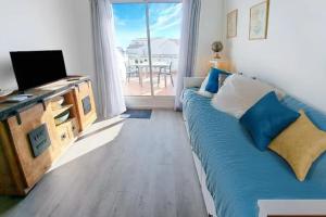 1 dormitorio con 1 cama y escritorio con TV en Appartement face à la mer - Saintes-Maries-de-la-Mer en Saintes-Maries-de-la-Mer
