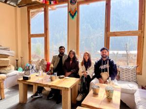 un grupo de personas sentadas en una sala de estar en Grham Hostel Kasol, Katagla en Kasol