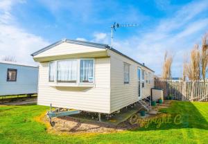 a small white tiny house in a yard at WW165 - Camber Sands Holiday Park - Sleeps 6 - 2 Bedrooms - 2 Bathrooms in Camber