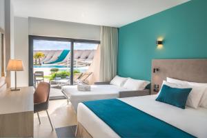 a hotel room with two beds and a balcony at Occidental Mar Menor in Cartagena