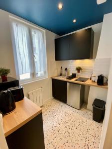 a kitchen with a sink and a counter top at Les Appartements du Grand Hôtel Clichy Paris in Clichy