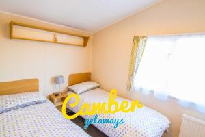 a bedroom with two beds and a window at SP90 - Camber Sands Holiday Park - Dog Friendly in Camber