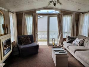 a living room with a couch and a chair and a window at MP709 - Parkdean Resorts, Camber Sands in Camber
