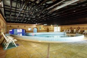 a large swimming pool in a large room with chairs at HO48 - Coghurst Hall - Hastings, East Sussex in Westfield