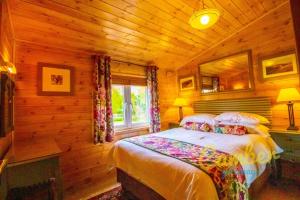 a bedroom with a bed in a log cabin at Rainbow Petty - Pine lodge - Kent countryside in Brookland