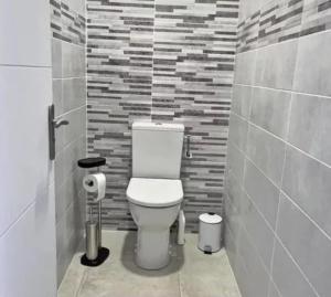 a bathroom with a toilet and a brick wall at Bel ppartement en plein Centre ville in Valras-Plage