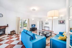 a living room with blue furniture and a fireplace at Villa Barrancos in Guia