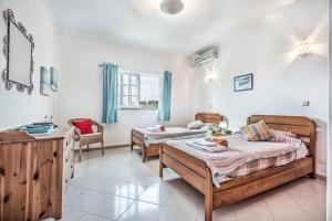 a bedroom with two beds and a dresser in it at Villa Barrancos in Guia +13 photos