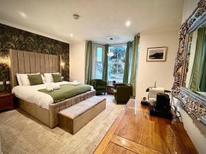 a bedroom with a large bed and a couch at Gwydyr Hotel in Betws-y-coed