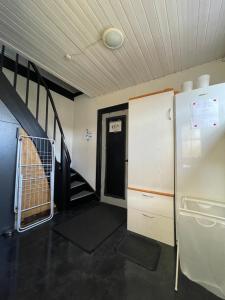 Cette chambre dispose d'un escalier, d'un réfrigérateur et d'une porte. dans l'établissement Overnatning tæt på Silkeborg, à Engesvang