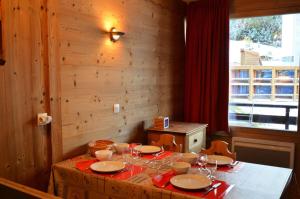 stół z talerzami i kieliszkami do wina w obiekcie Résidence Villaret - Studio pour 4 Personnes 234 w Les Menuires