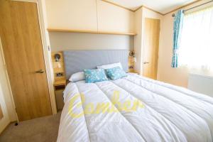 a bedroom with a large white bed with blue pillows at MP735 - Parkdean, Camber Sands in Camber