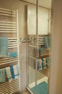una doccia con porta in vetro in bagno di B&B la récré de Bauffe 