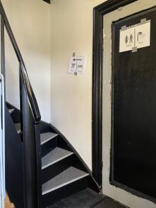 - un escalier avec une porte noire dans la chambre dans l'établissement Overnatning tæt på Silkeborg, à Engesvang