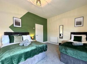 two beds in a room with green walls at Charming 4-Bedroom House in Liverpool w/ WiFi - Sleeps 10 by PureStay in Liverpool