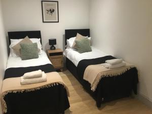 a bedroom with two beds with towels on them at 7a in London