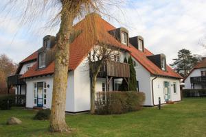 a white house with an orange roof at Kormoran Harry´s Place Q8 in Prerow