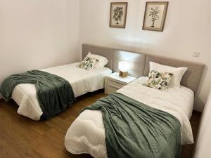 Zimmer mit 2 Betten und einem Tisch mit einer Lampe in der Unterkunft Largo das Calçadas in Porto de Mós